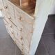 Craft cabinet with drawers with a very old tobacco advertisement in the background