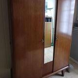 Vintage 1960s wooden wardrobe with a central mirror and tapered legs.