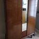 Vintage 1960s wooden wardrobe with a central mirror and tapered legs.