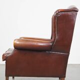 Dark English style sheepskin wingback chair with character and patina
