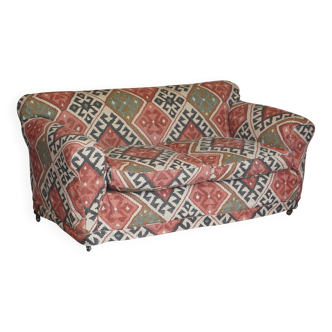 Victorian canapé upholstered in Kilim with turned mahogany legs.
