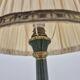 Brass table lamp with green patina and empire-style fabric shade.