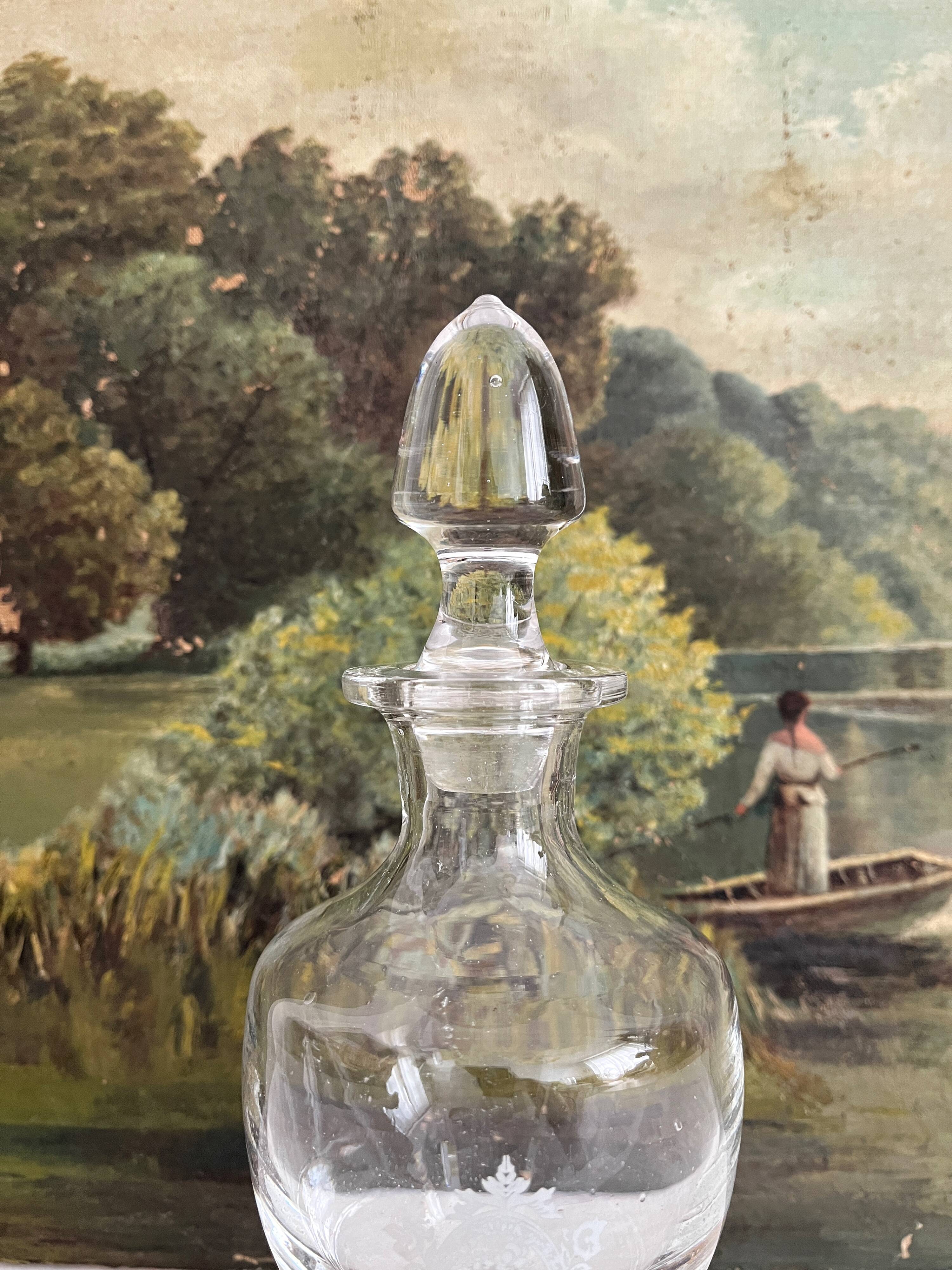 Antique stemmed blown glass bottle with engraved medallion
