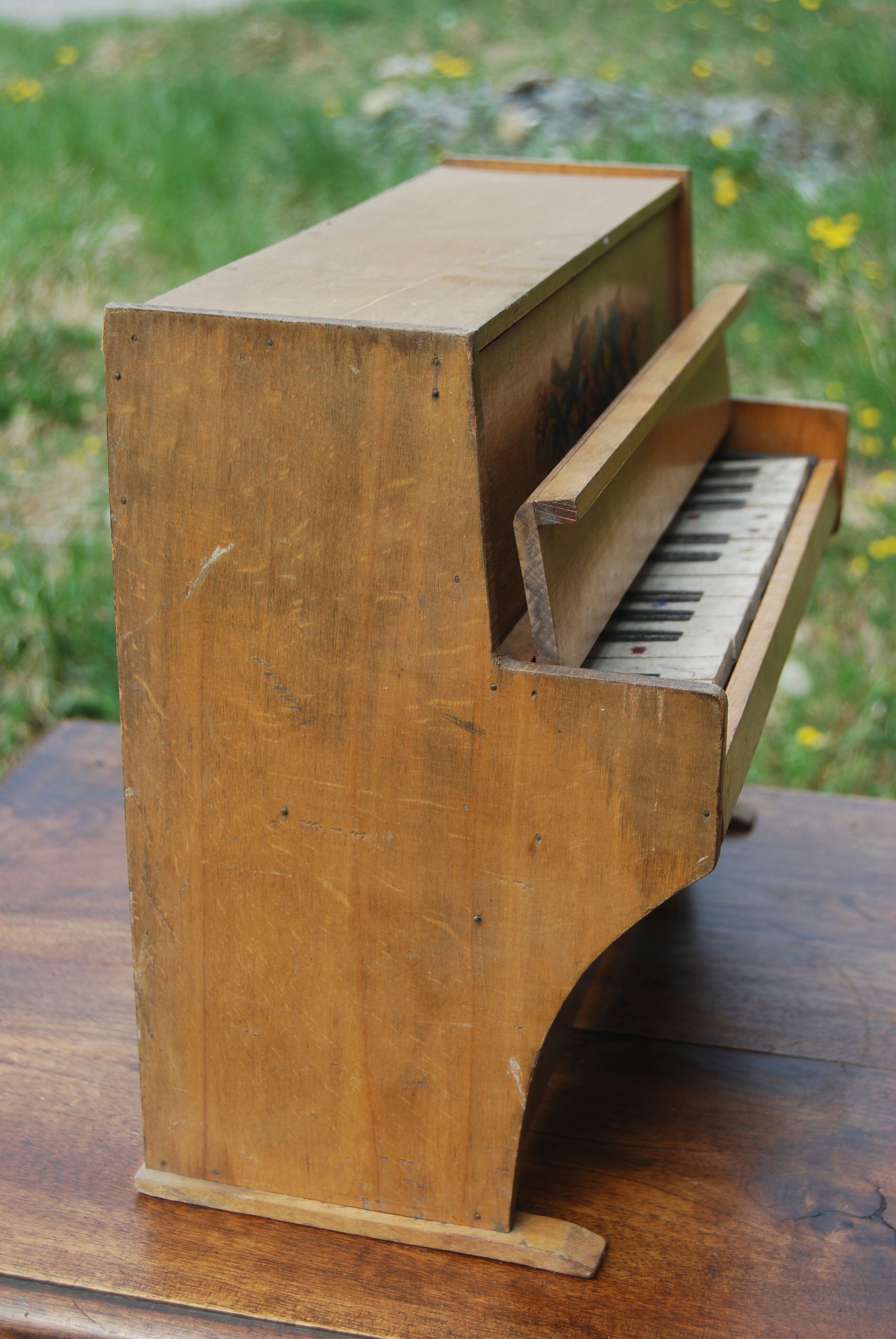 Ancient toy, wooden piano, decorating birds on rose bush