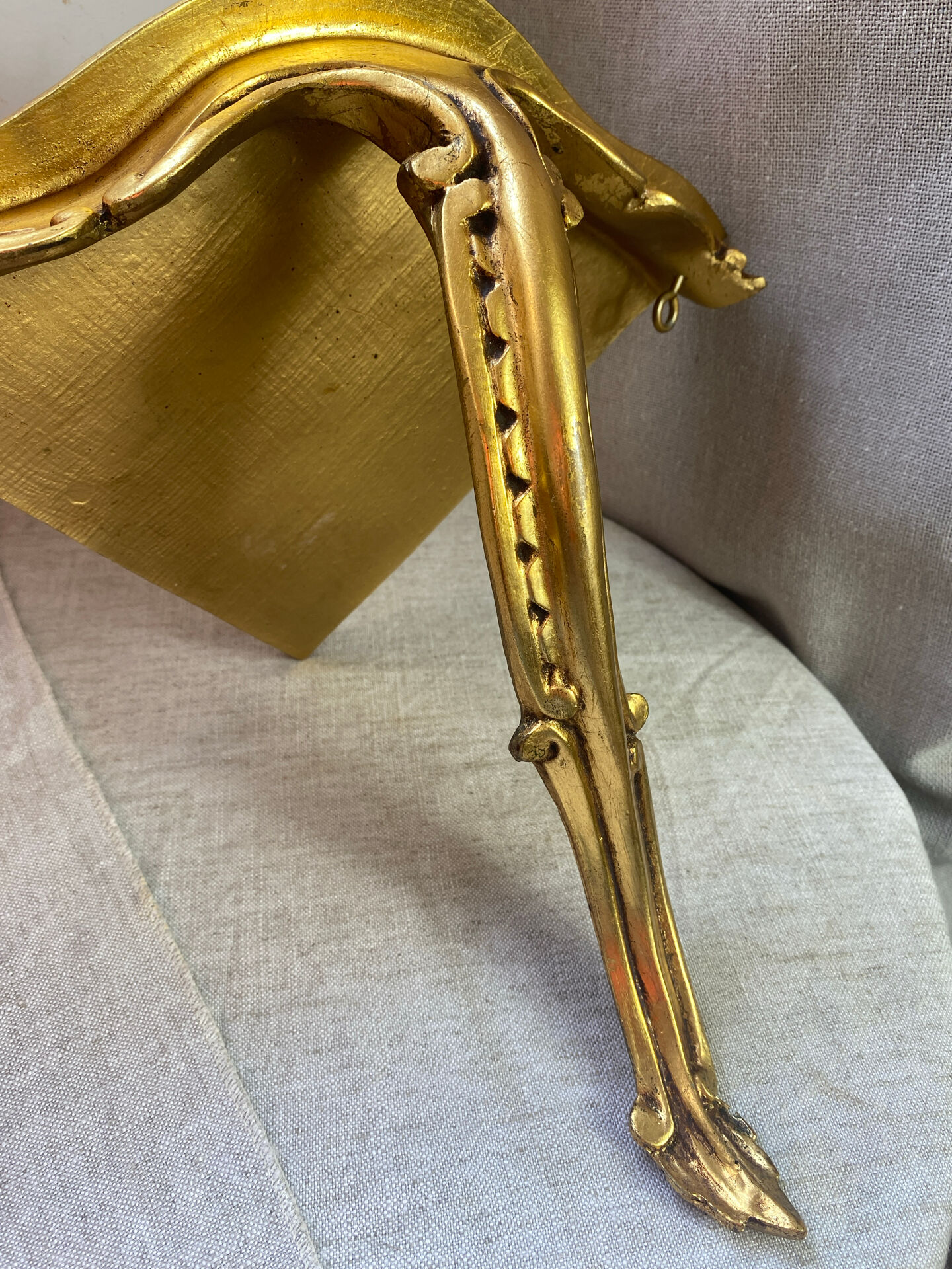 Small corner console in resin with a gold finish.