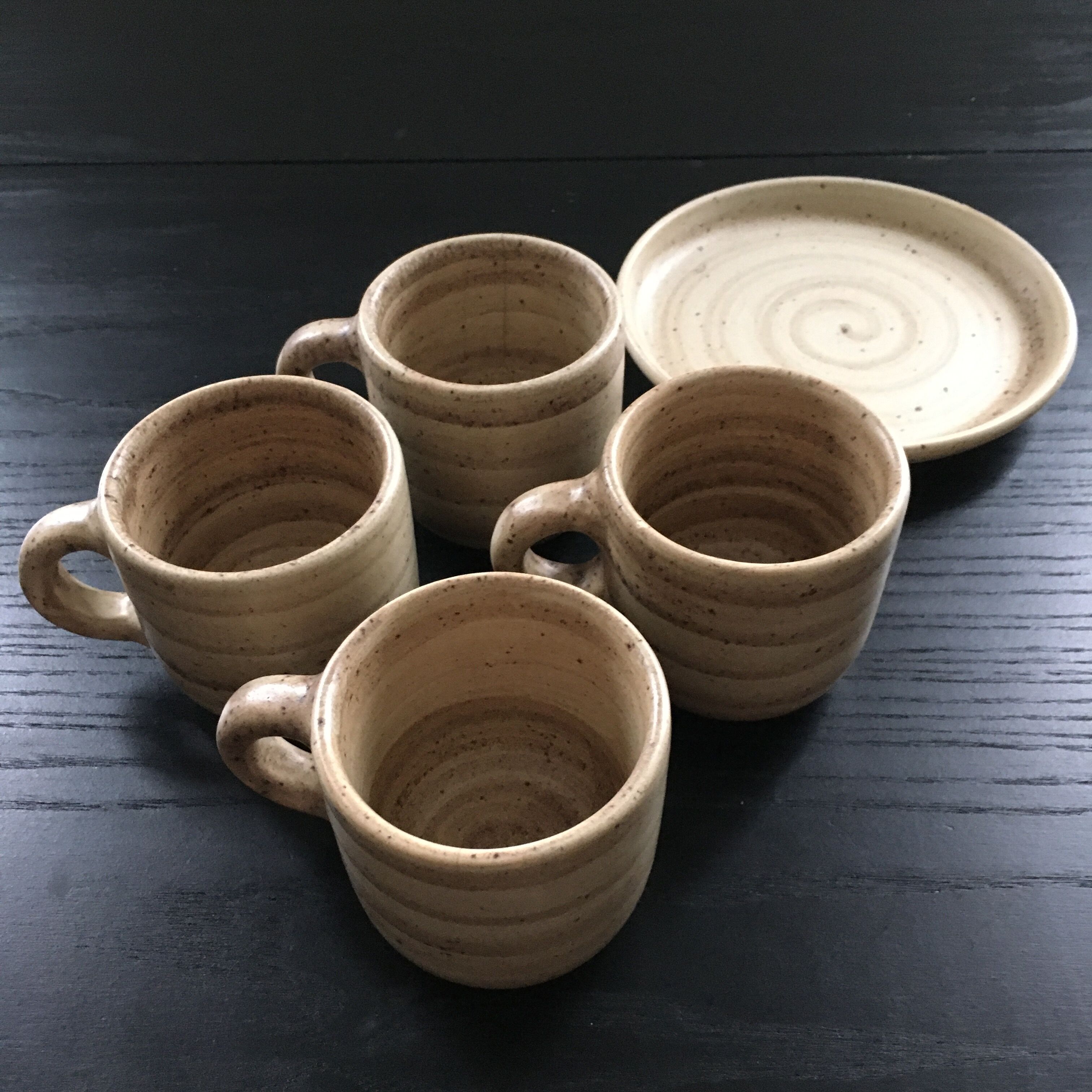 Set of 4 beige stoneware mugs.