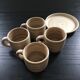 Set of 4 beige stoneware mugs.