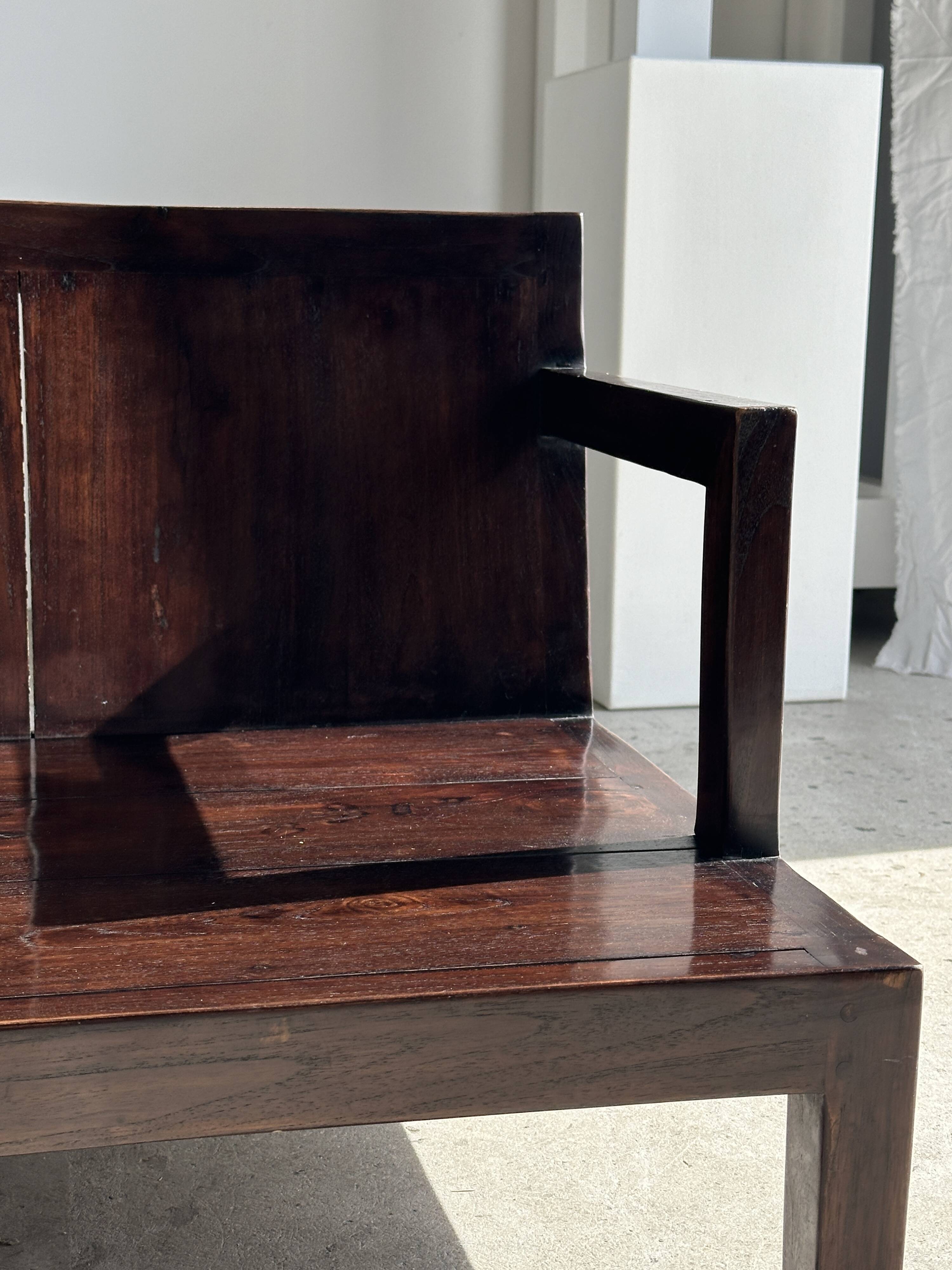 Small low armchair in varnished brown wood