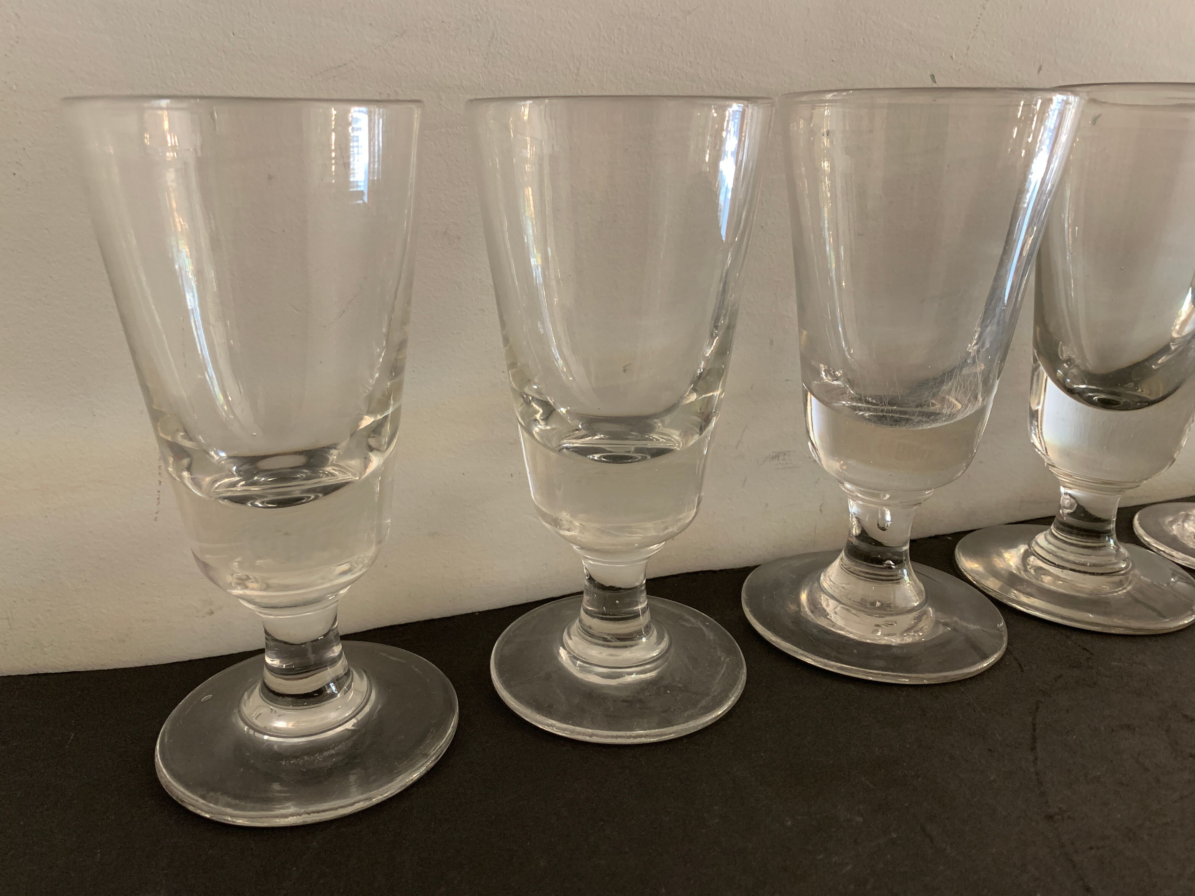 12 old glasses on foot at bistro or absinthe