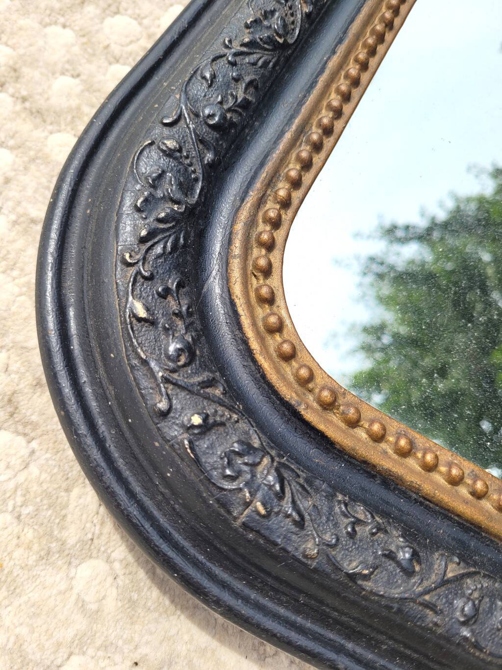 Antique mirror in Napoléon III style, blackened with beaded frieze, 42x55cm.