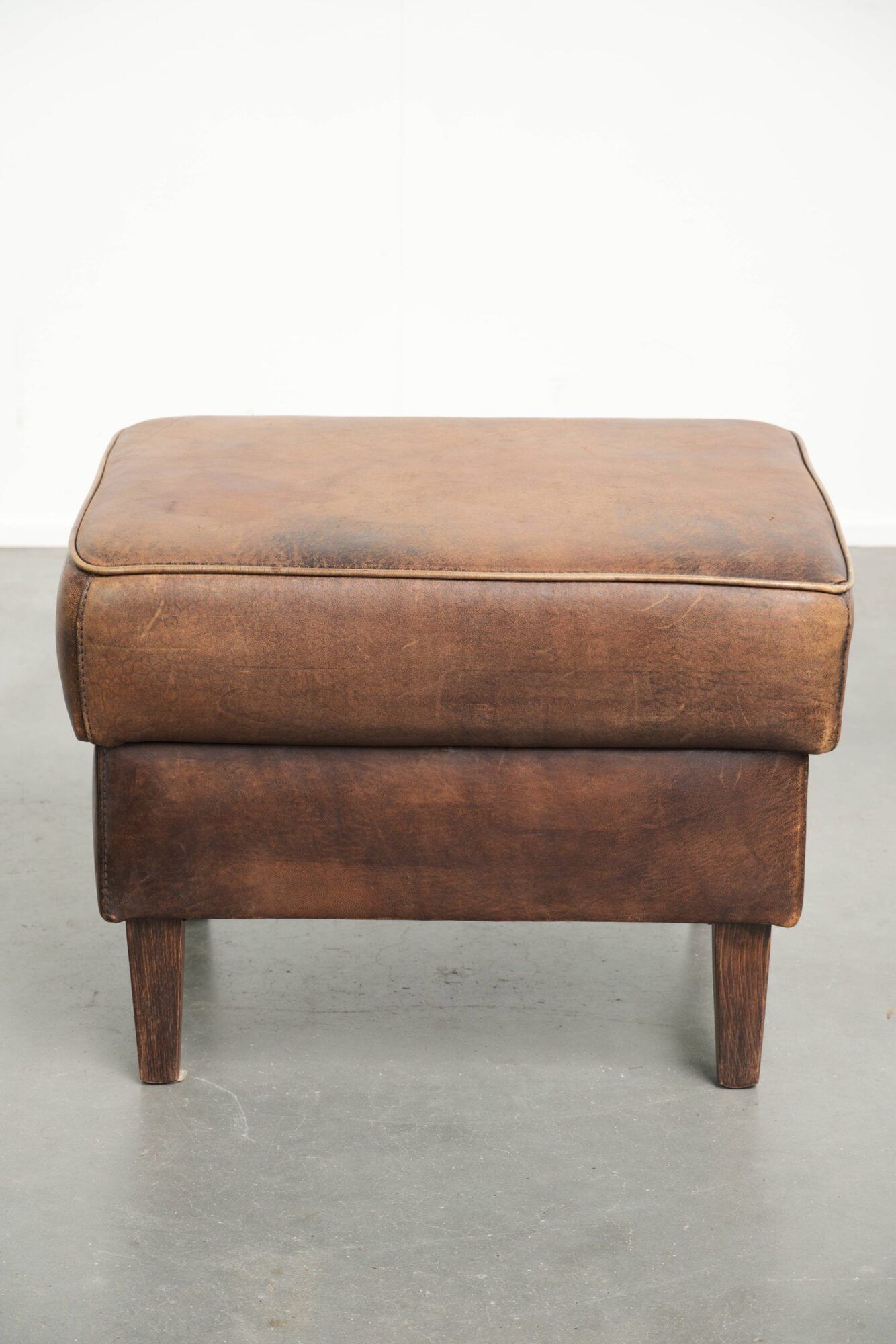 Sheepskin ottoman with a light brown colour scheme and a vintage look