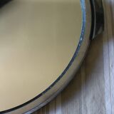 A large round mirror tray with metal handles