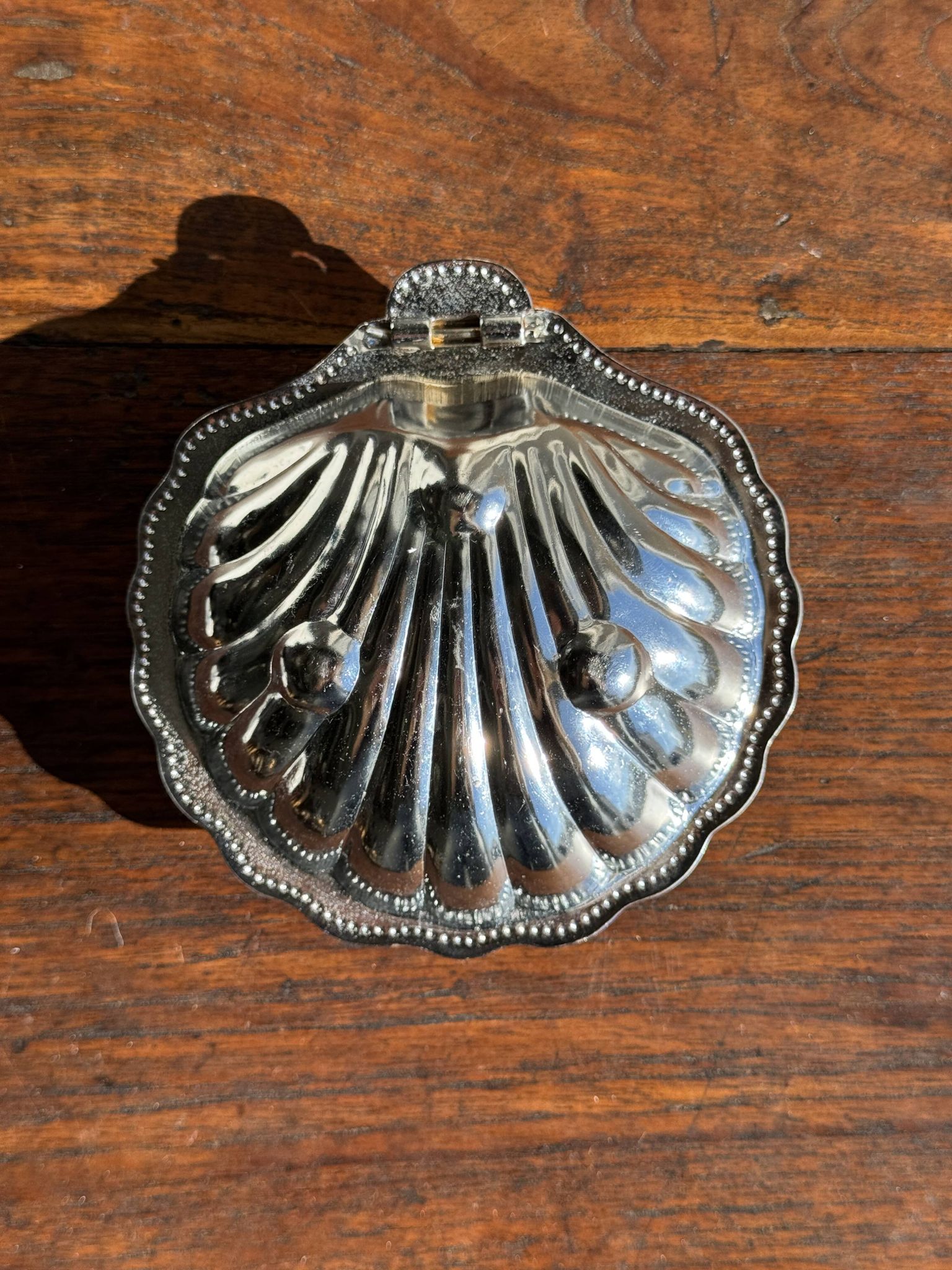 Vintage silver-plated shell butter dish with blue bowl.