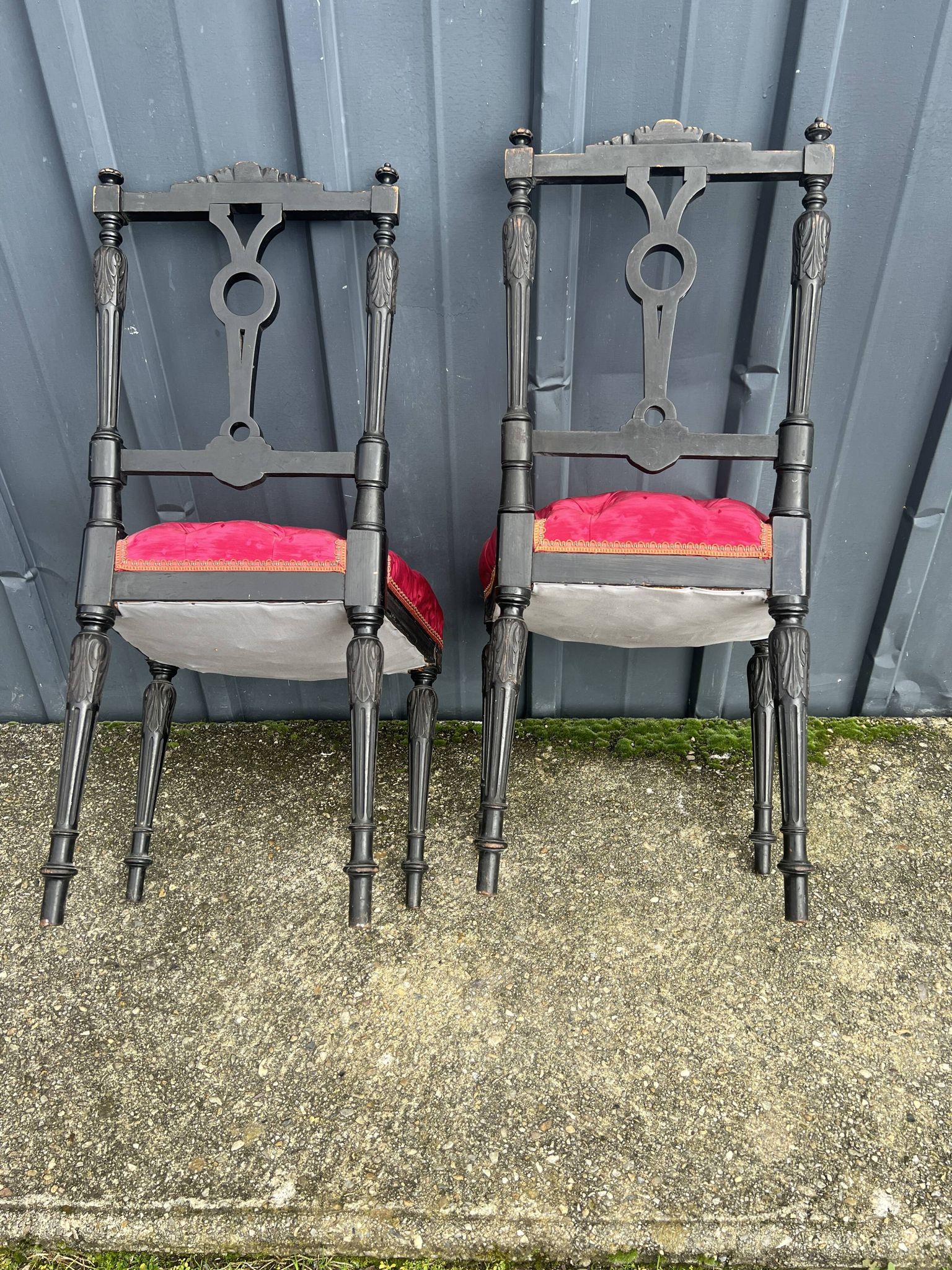 Pair of black lacquered chairs with purple tufted upholstery.