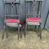 Pair of black lacquered chairs with purple tufted upholstery.