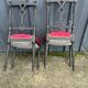Pair of black lacquered chairs with purple tufted upholstery.