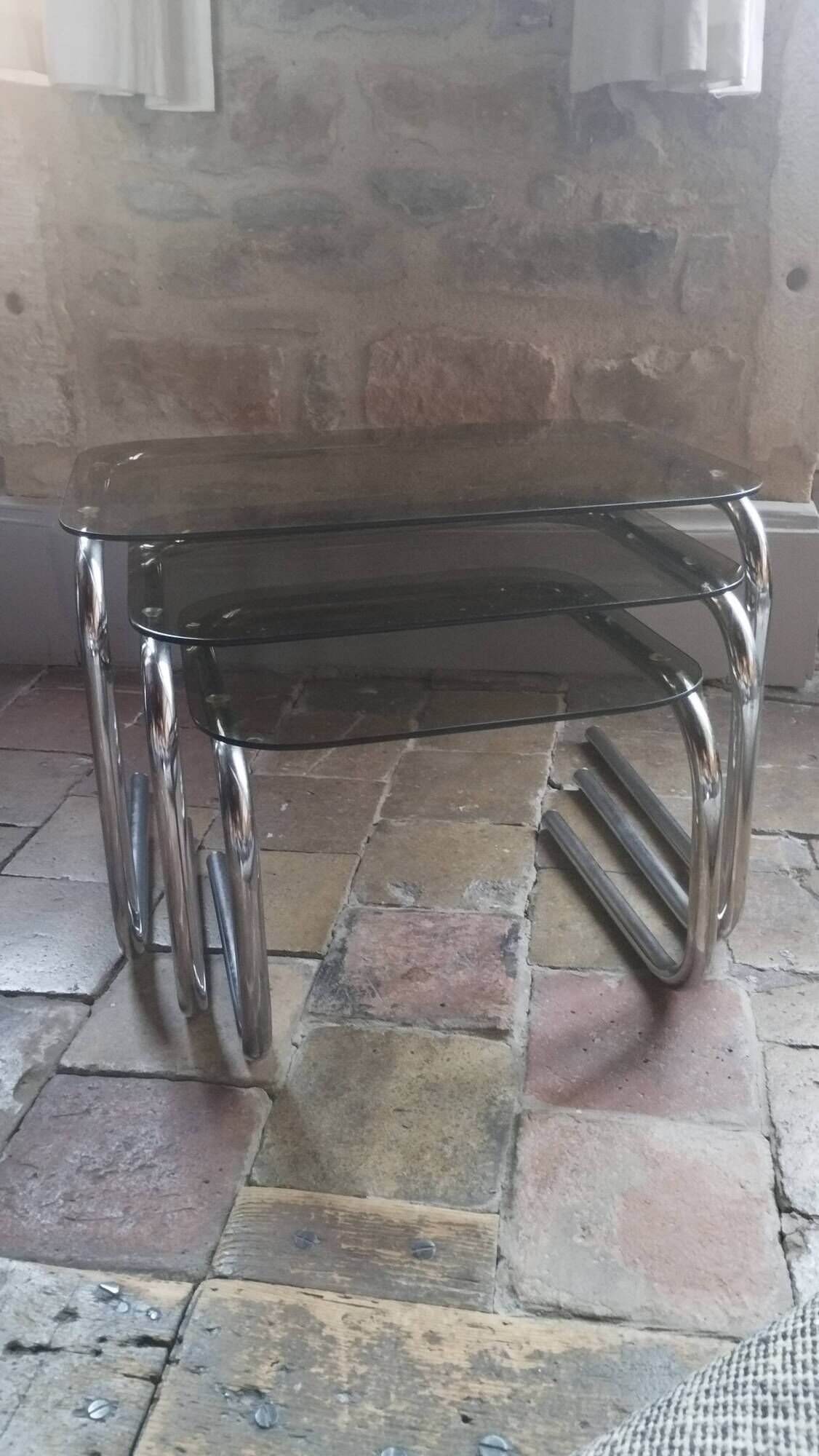 Nest of tables in glass and chrome steel.