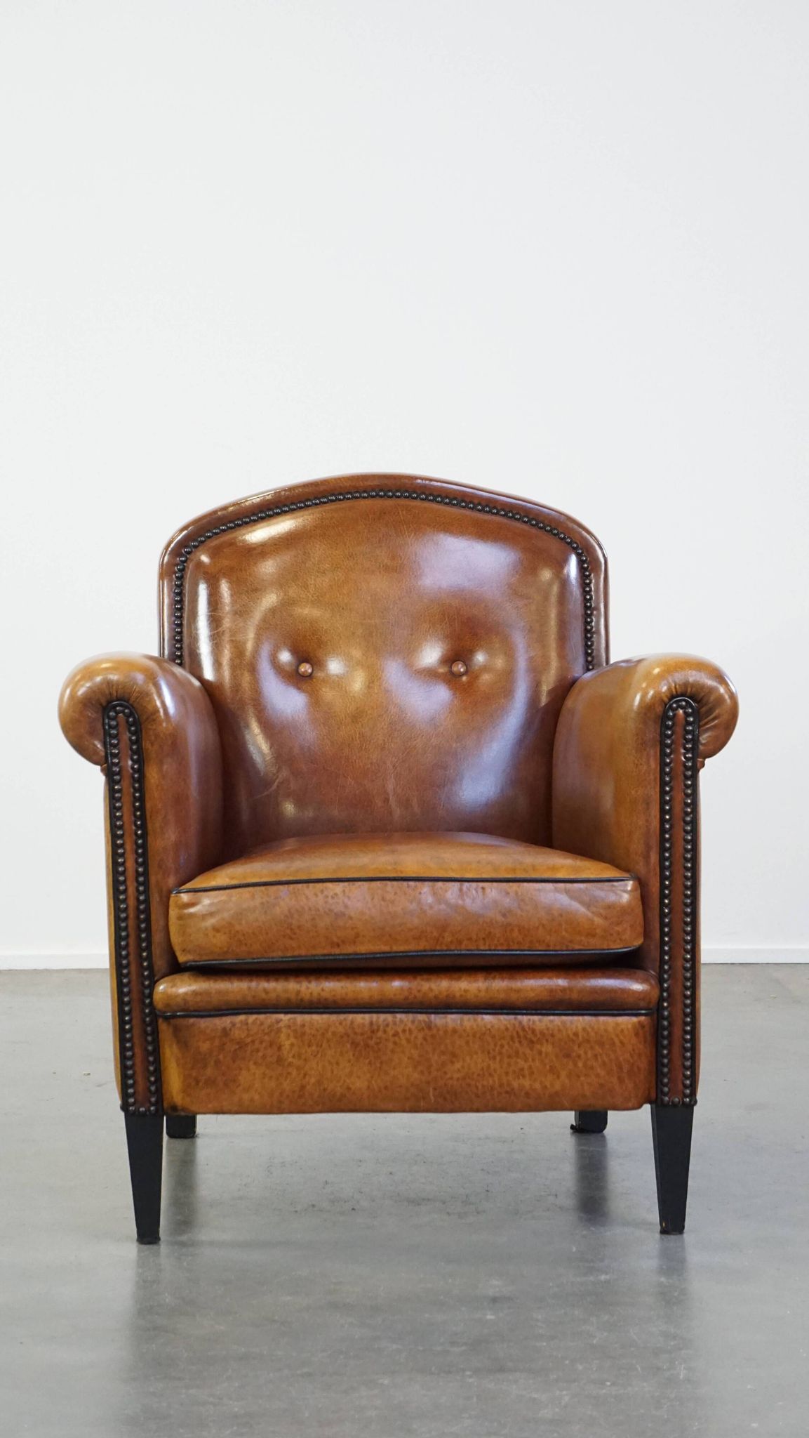 Sheep leather design armchair finished with decorative nails and black piping
