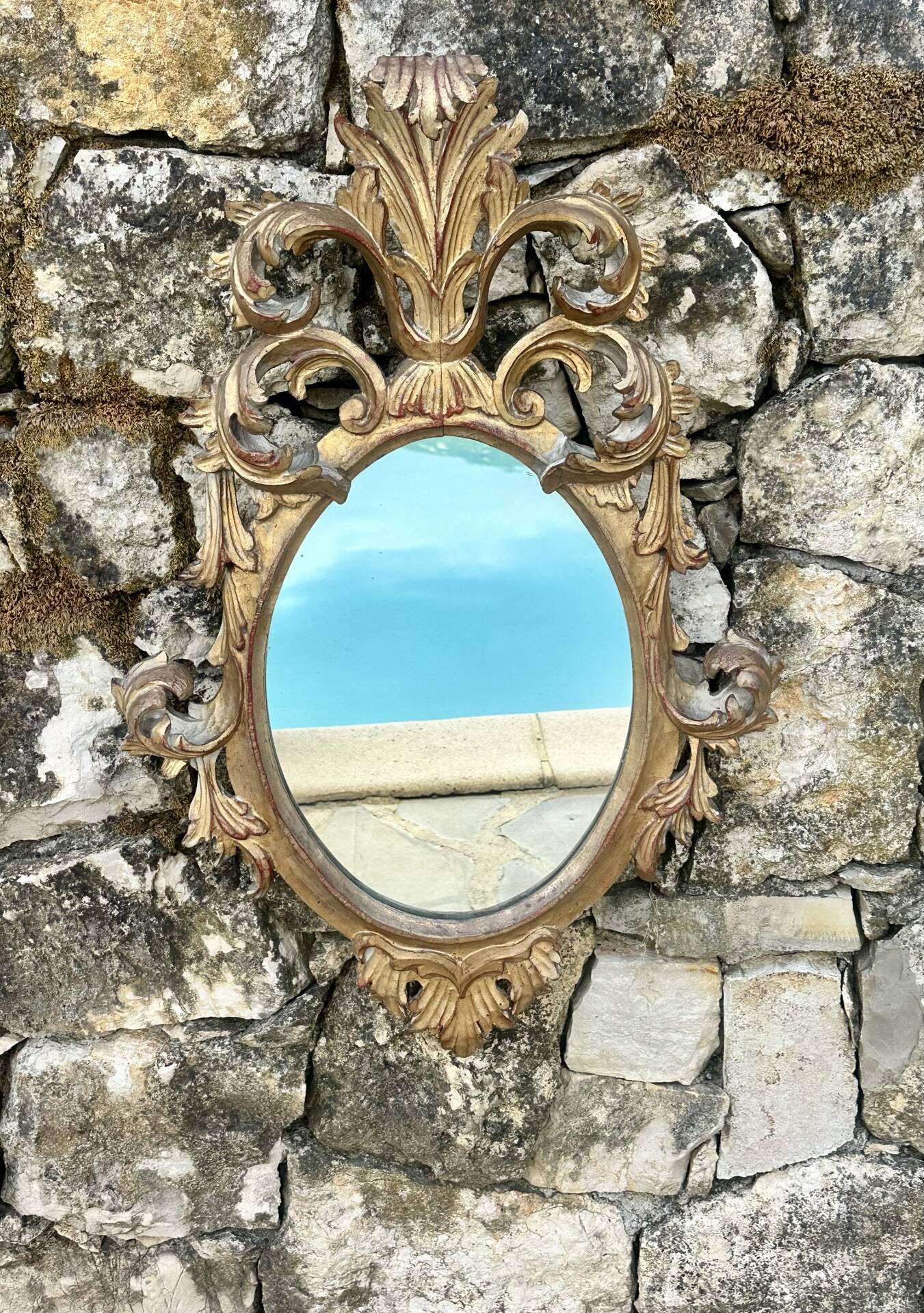 Miroir en bois doré sculpté .