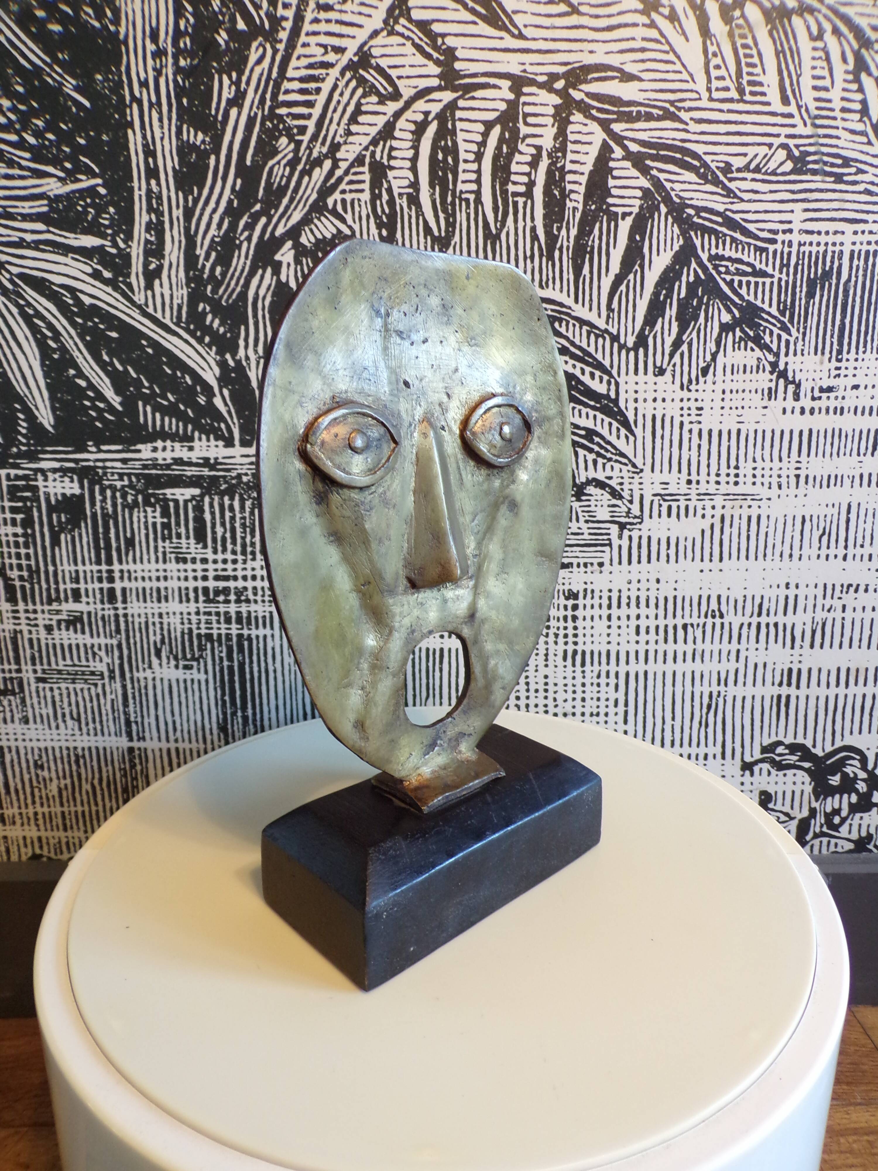 brutalist bronze face sculpture