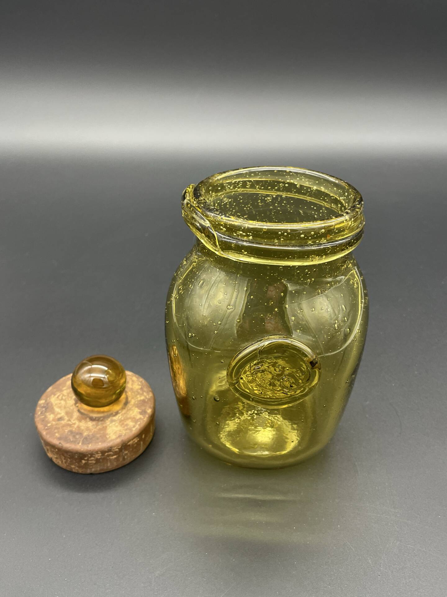 Yellow bubbled glass apothecary jar with cork lid.