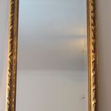 Miroir ancien doré surmonté d'un fronton et glace biseautée