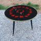 Vintage coffee table with glass top and tripod legs in blackened wood from the 1960s.