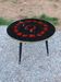 Vintage coffee table with glass top and tripod legs in blackened wood from the 1960s.