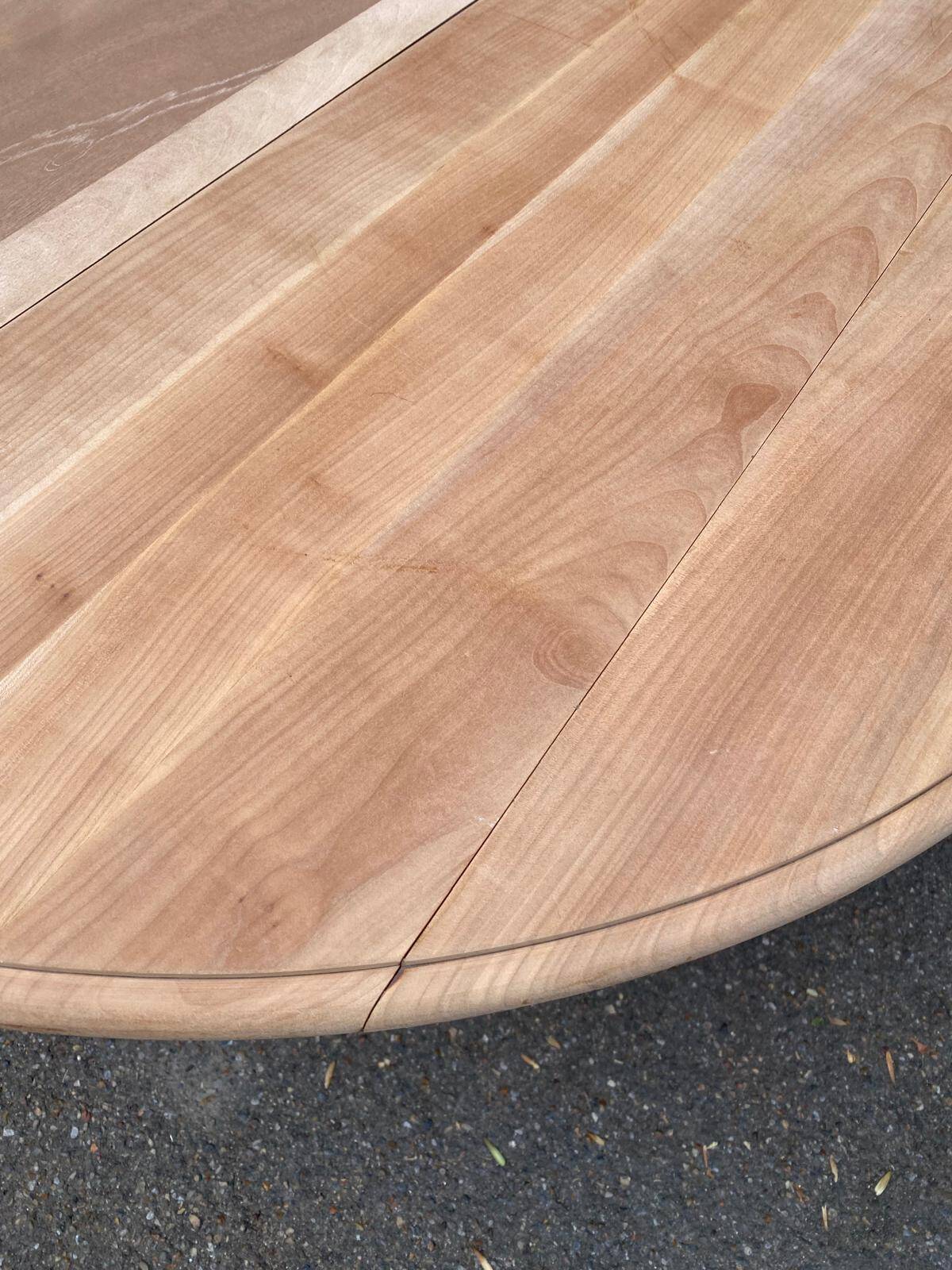 Round dining table with a central pedestal, extendable, stripped in solid walnut with 2 extensions.