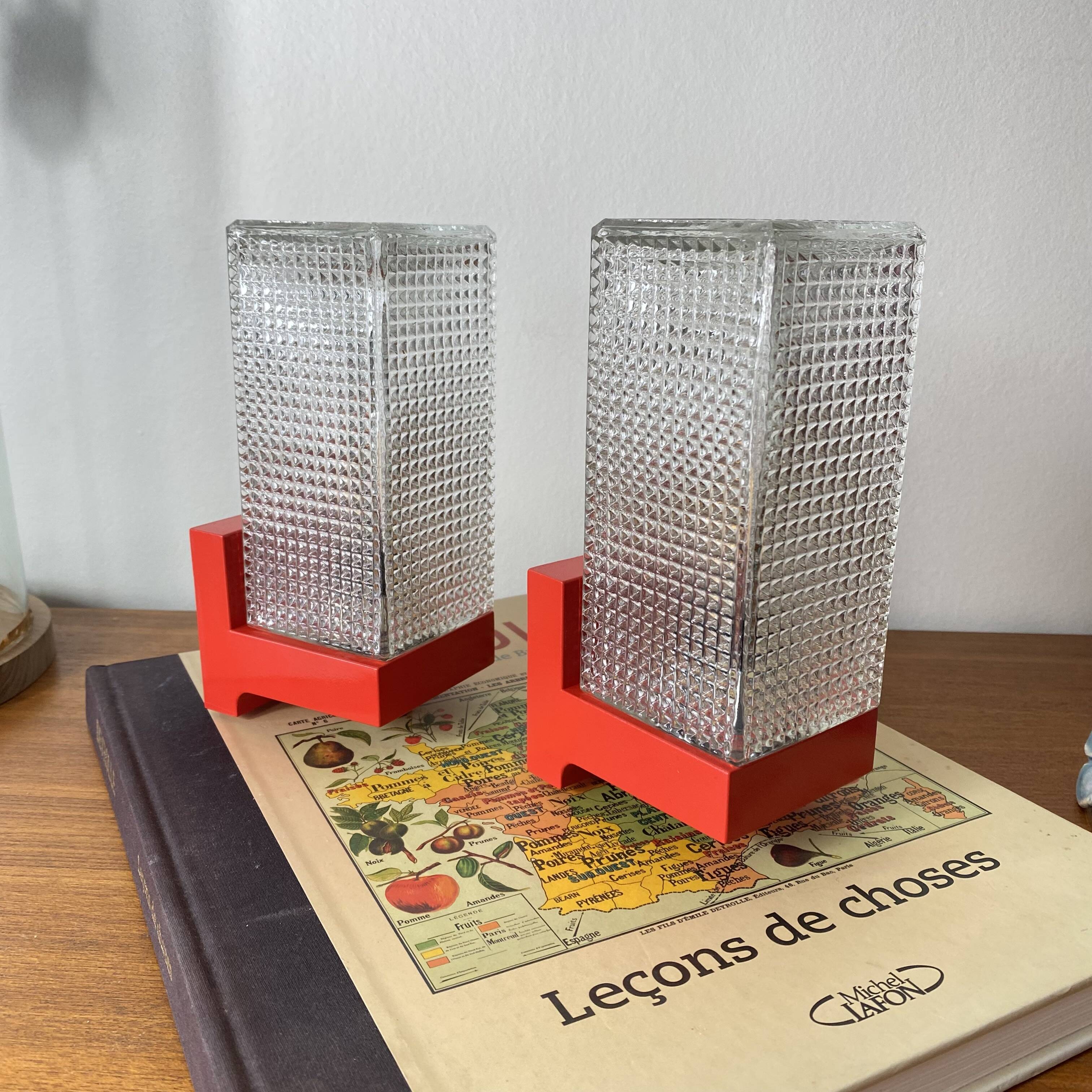 Pair of vintage wall lights in red plastic and clear glass.