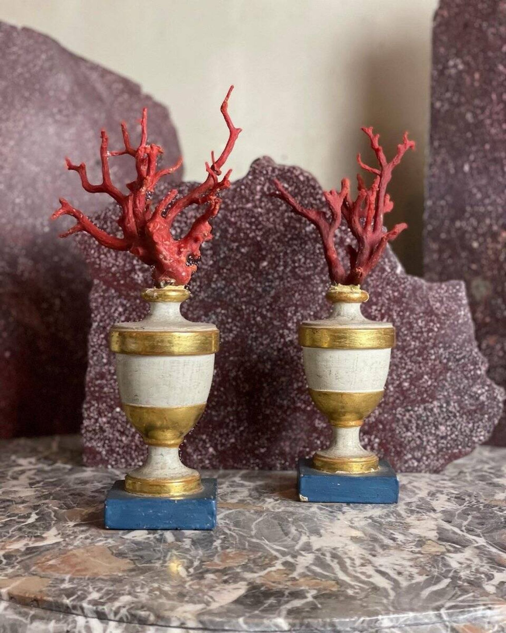 Pair of red corals on gilded and blue wooden bases