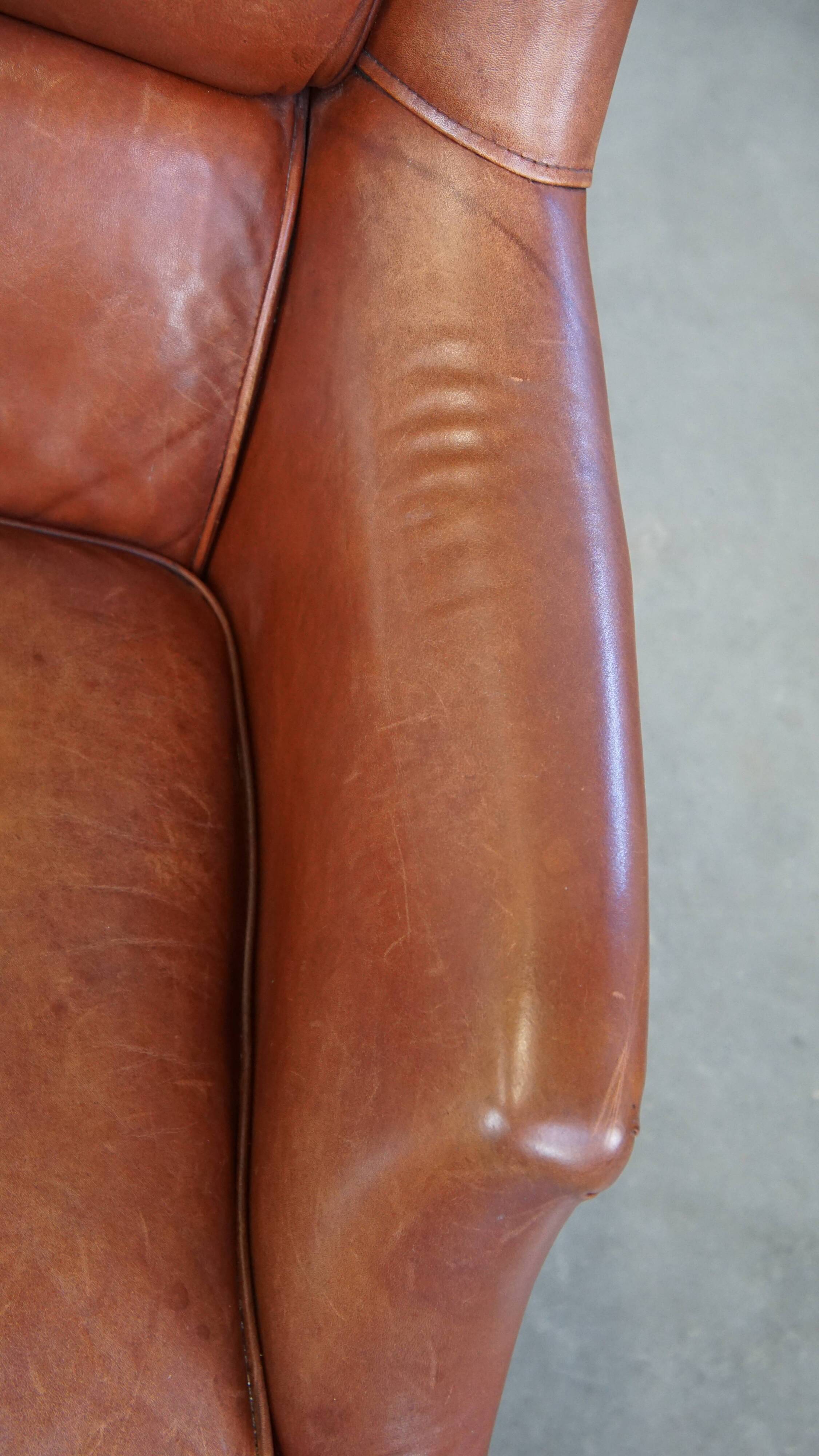 Cowhide armchair in good condition, finished with decorative nails