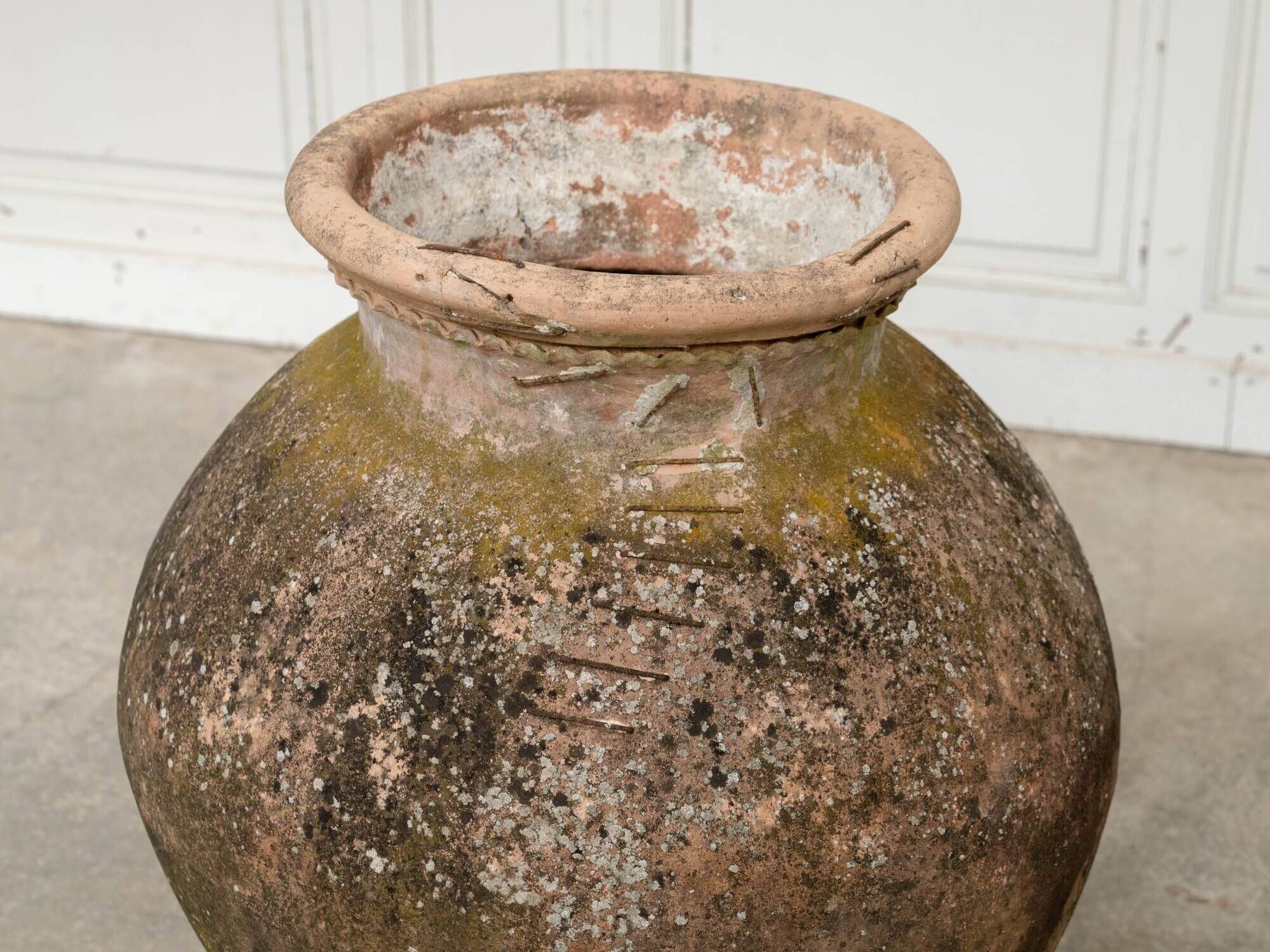 Old terracotta jar with its metal clasps, late 19th century.