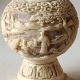 Asian-inspired ball vase. In beige cinnabar lacquer. Scenes of life decor. Arabesque and floral friezes. Height 24 cm