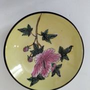 A pair of vintage Chinese decorative plates with floral designs on a yellow background.