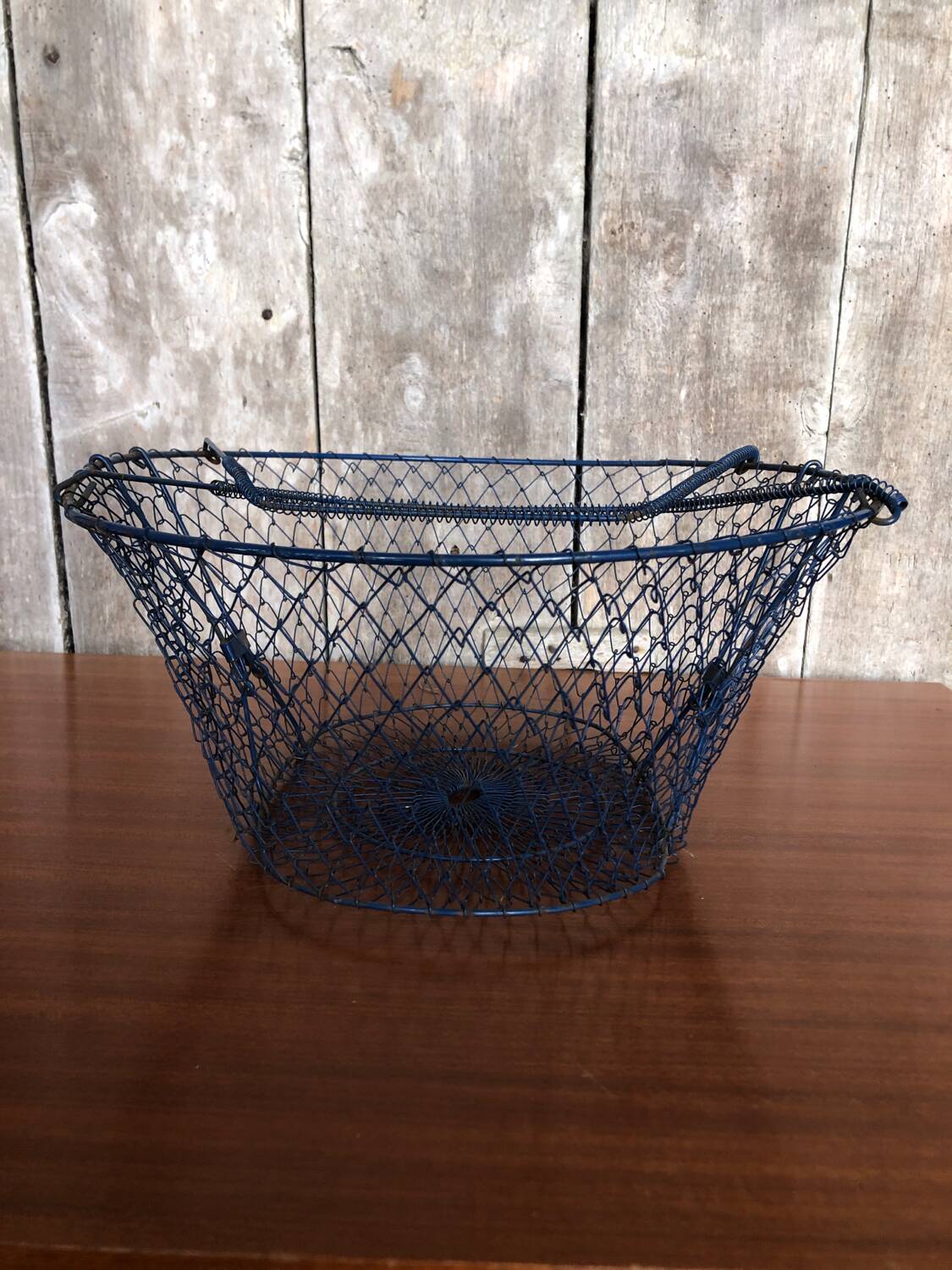 Old foldable blue metal basket, vintage handles