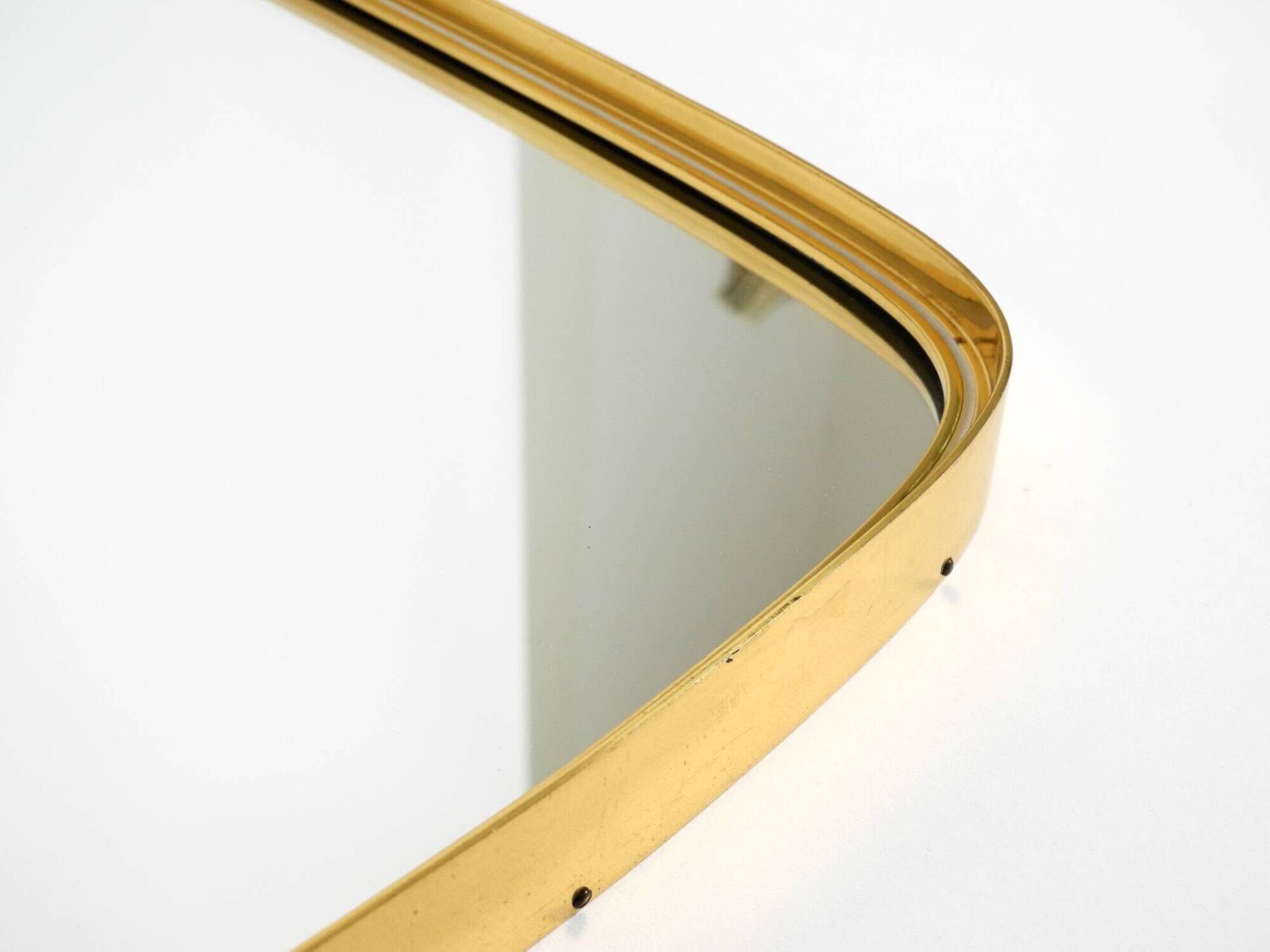 A pair of rare Mid Century "Münchener Zierspiegel" brass wall mirrors