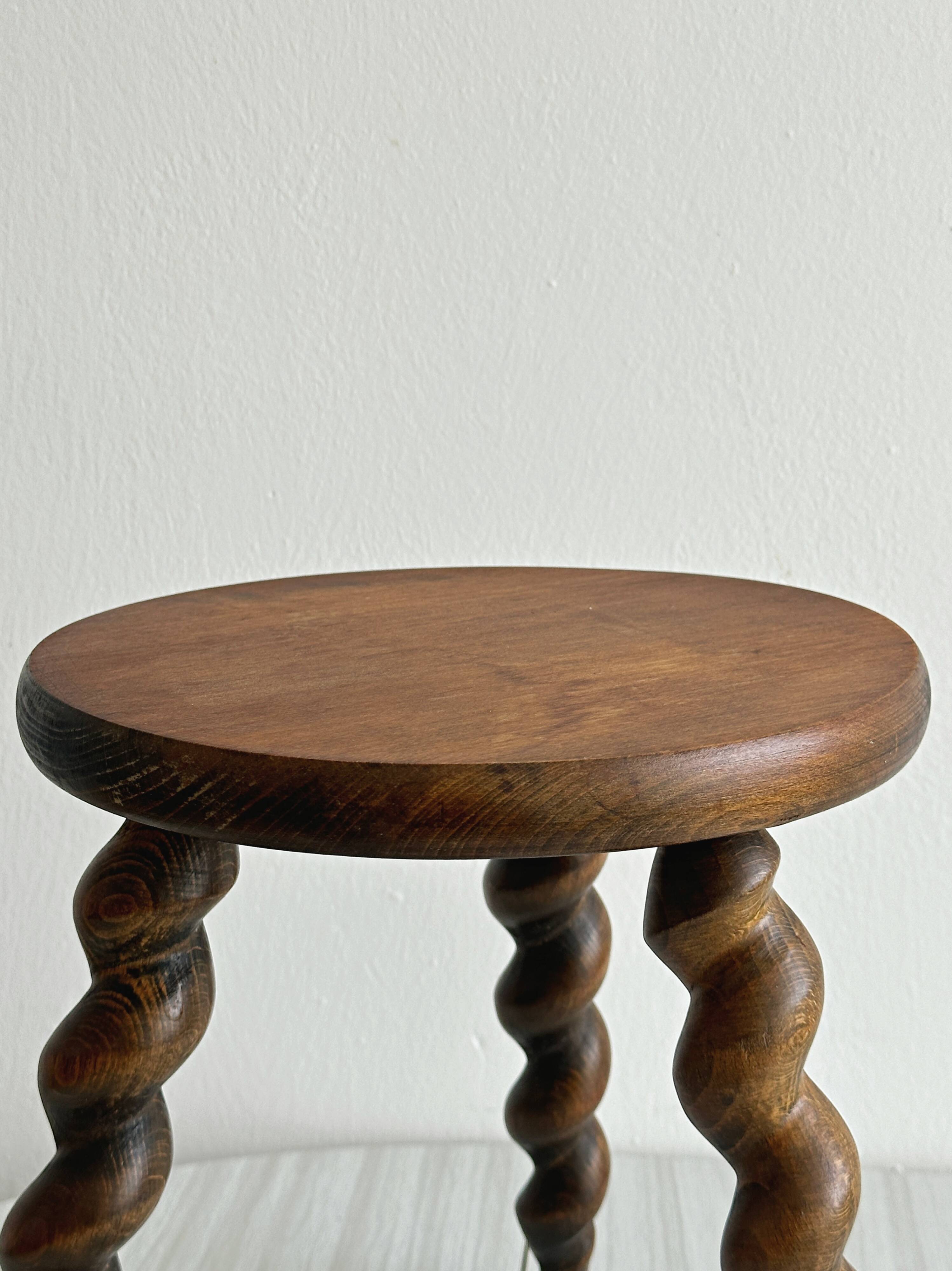 Small antique tripod stool in dark wood.