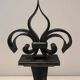 Important pair of wrought iron andirons with torch in heraldic fleur-de-lis design.