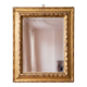 Antique wall mirror with a carved gilded frame featuring leaf motifs.