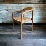 Solid wood chair with woven seat and armrests