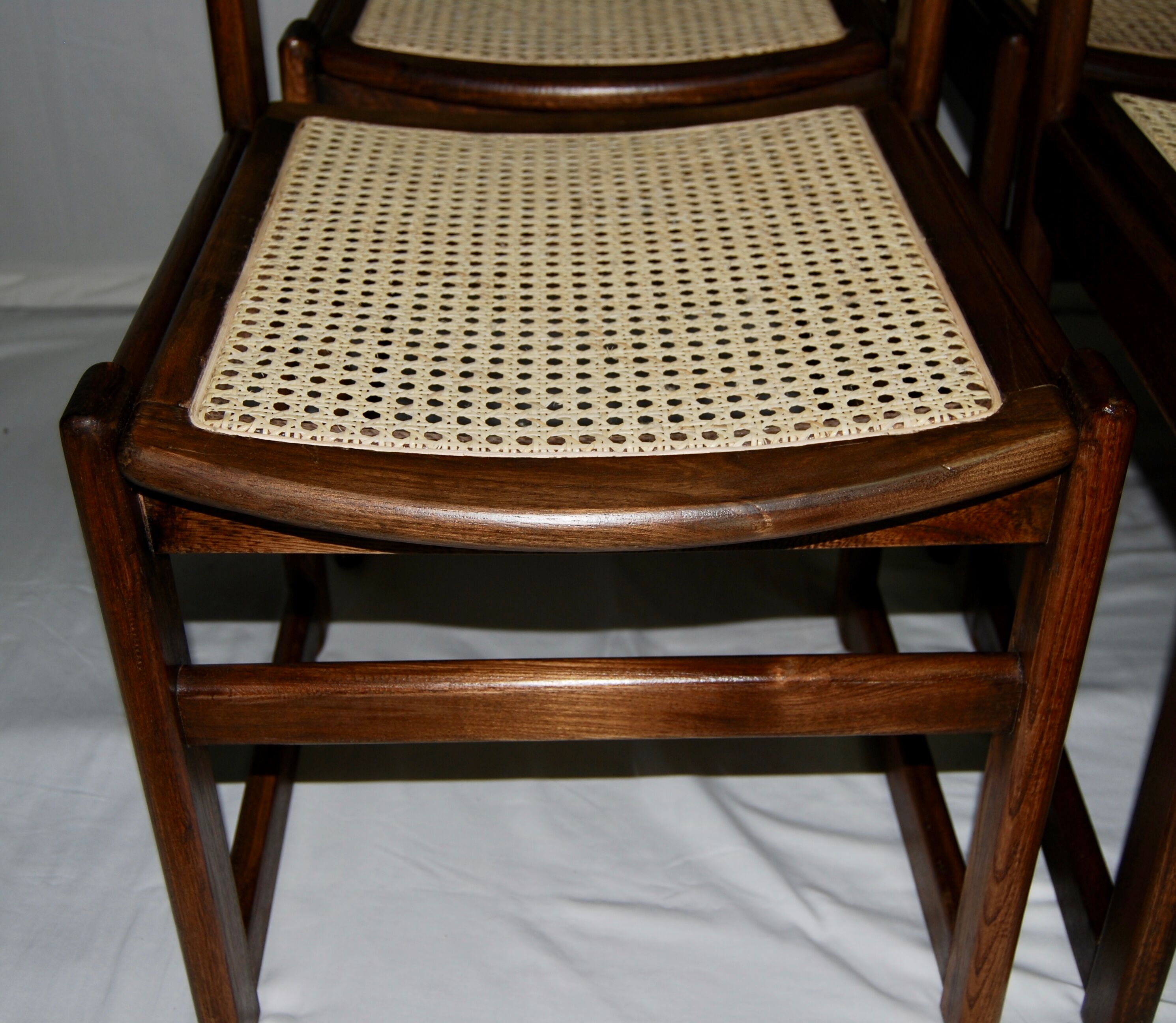 Set of 12 "sledge" dining chairs in walnut and cane.