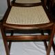 Set of 12 "sledge" dining chairs in walnut and cane.