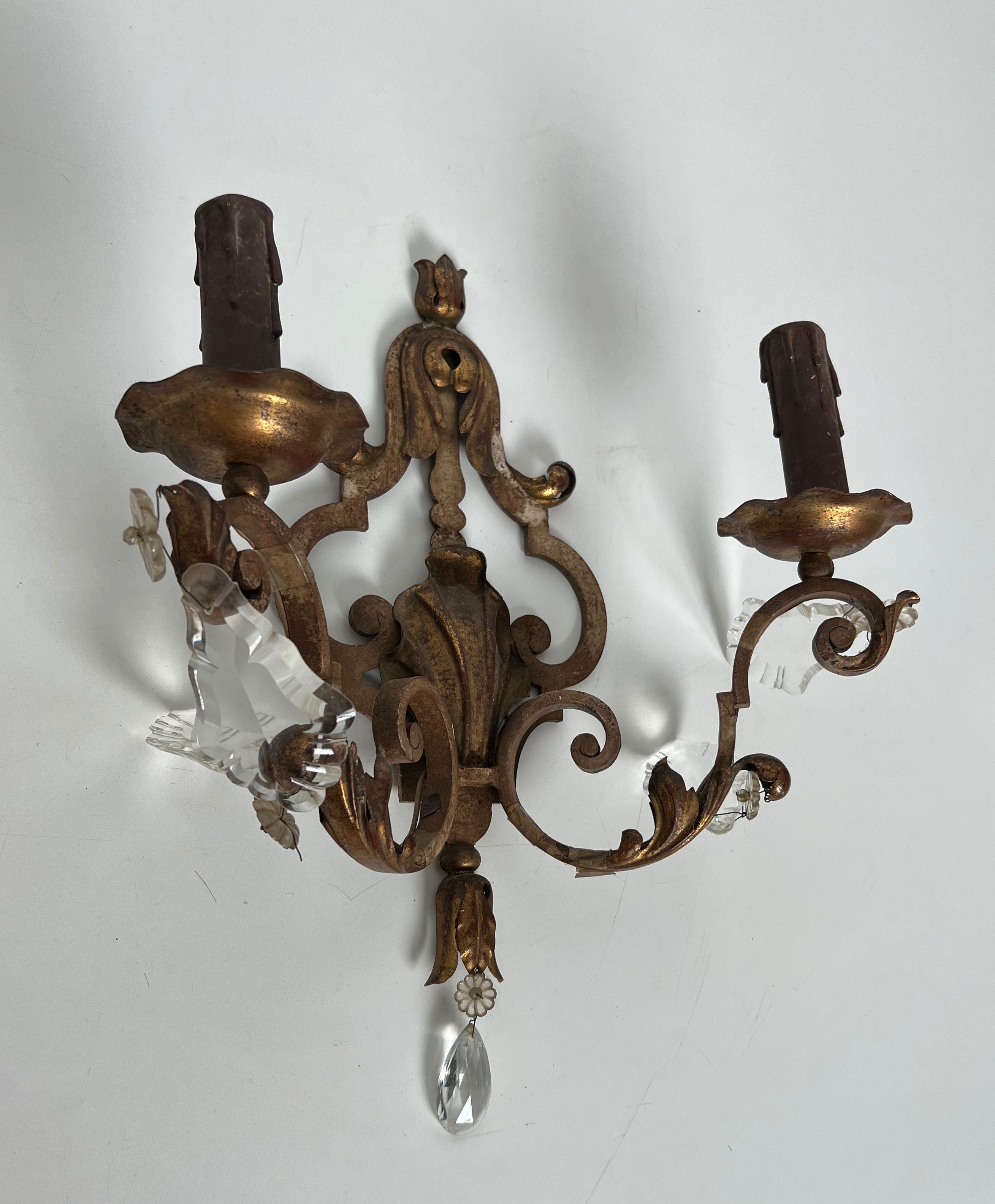 Pair of patinated wrought iron wall sconces with golden acanthus leaves and crystals.