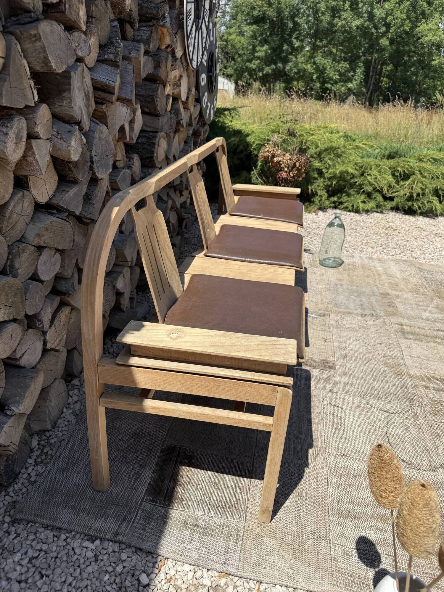 Baumann bench with wooden frame and faux leather seat.