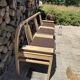 Baumann bench with wooden frame and faux leather seat.