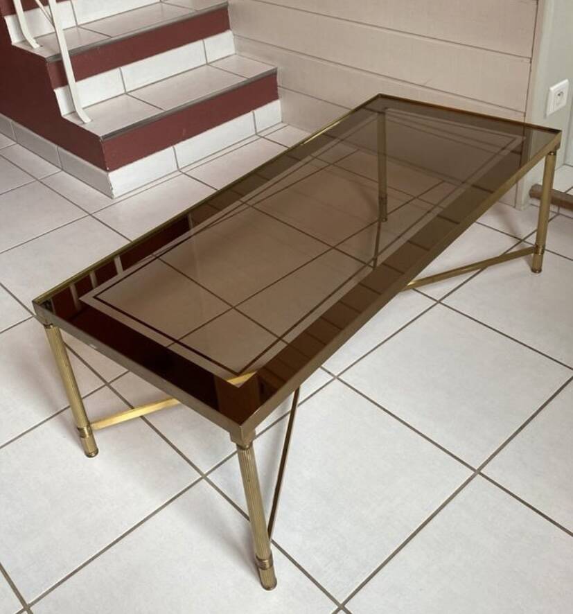 Rectangular neoclassical coffee table in gilded brass with a glass top.