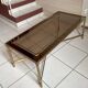 Rectangular neoclassical coffee table in gilded brass with a glass top.