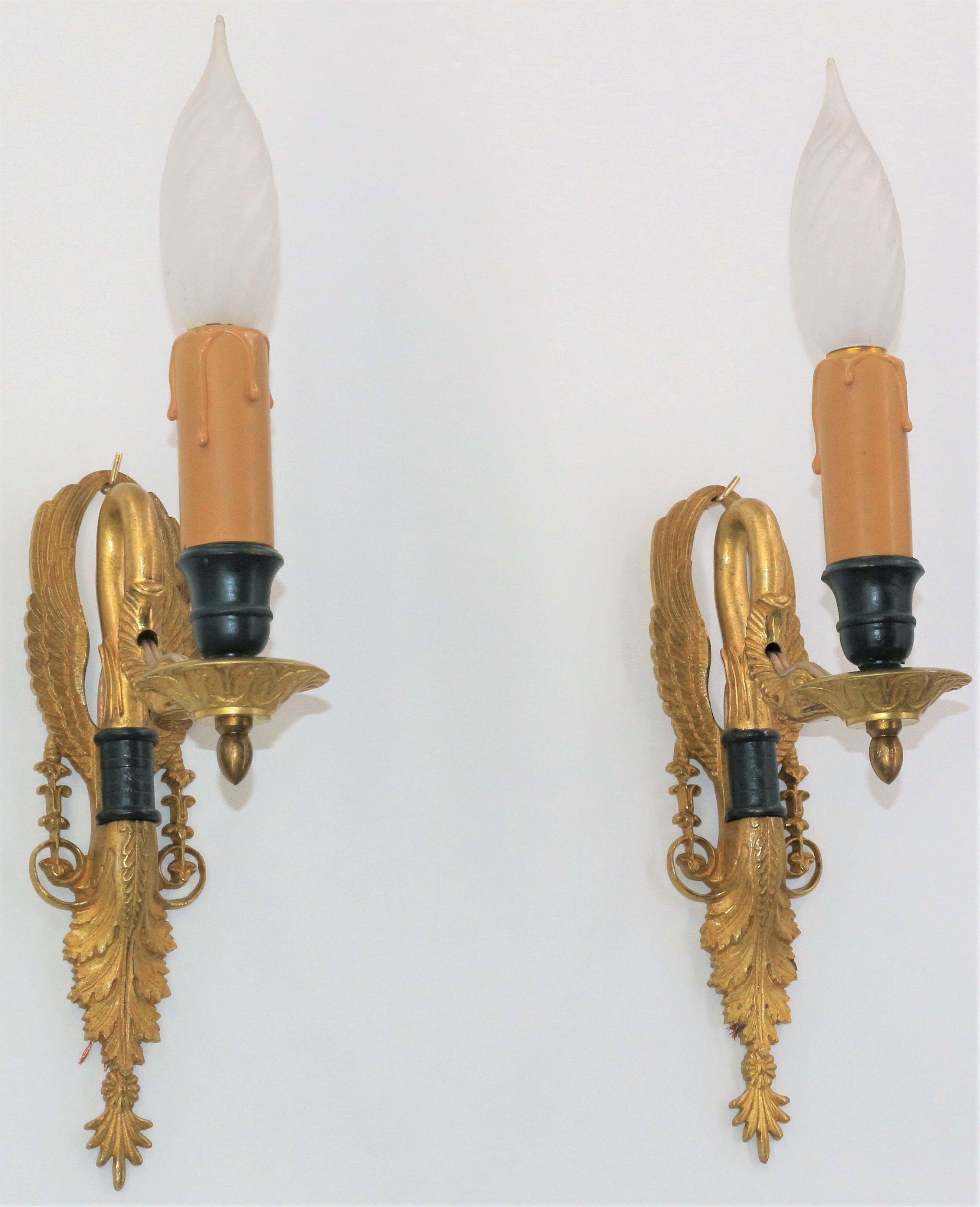 Pair of golden bronze wall lamps in triumphant empire swan style