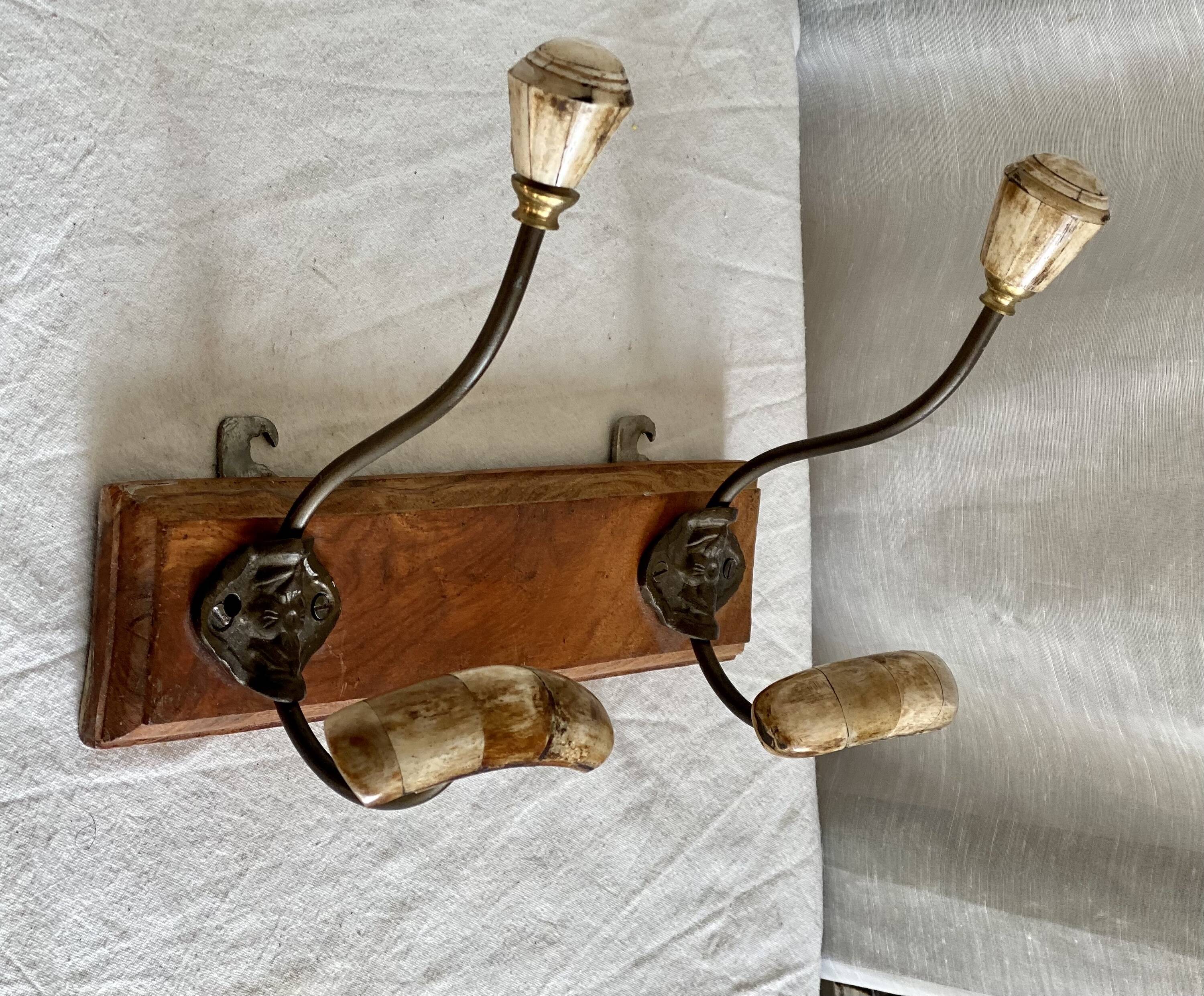 19th-century wall coat rack with 2 metal and horn hooks.